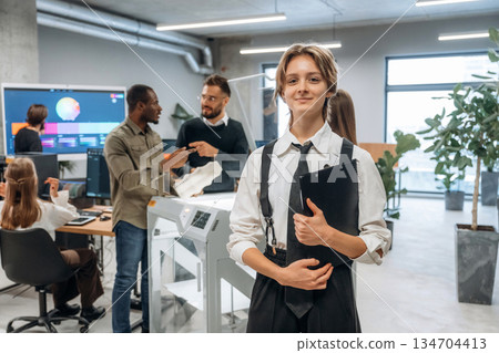 Woman is standing in front of colleagues. People are in the office by the 3d printer 134704413