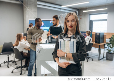 Young woman is standing in front of colleagues. People are in the office by the 3d printer 134704418