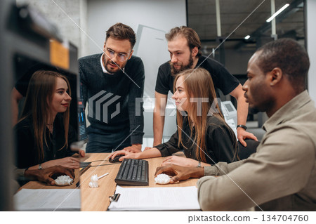 By computer. Designer team are together in the office By computer. Designer team are together in the office 134704760