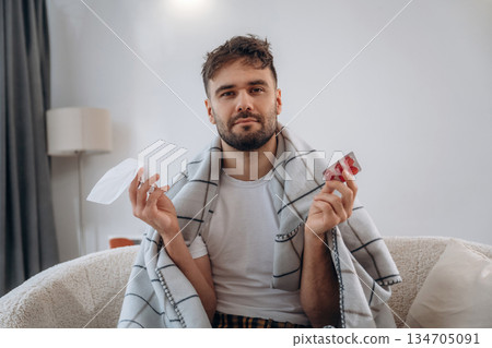 Napkin and blister of pills. Sick man is feeling bad at home Napkin and blister of pills. Sick man is feeling bad at home 134705091