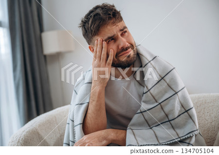 Sad, crying, depression. Sick man is feeling bad at home 134705104