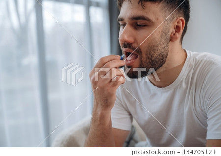 Medicine, taking pill. Sick man is feeling bad at home 134705121