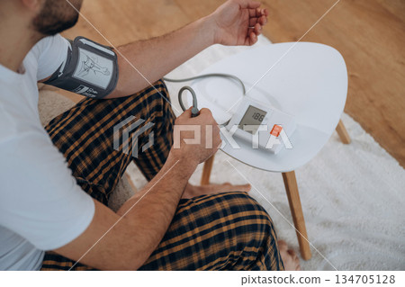 Man is sitting and measuring blood pressure Man is sitting and measuring blood pressure 134705128