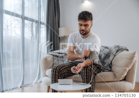 Blood pressure measuring. Sick man is feeling bad at home 134705130