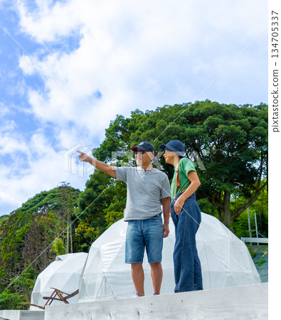 A couple pointing and checking outdoors [Photography cooperation: Oki Seaside Resort Miyabi] 134705337