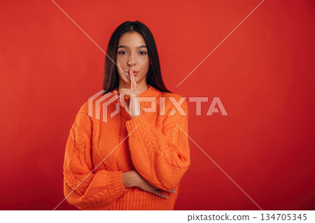 Silence, be quiet. Young beautiful woman is against background Silence, be quiet. Young beautiful woman is against background 134705345