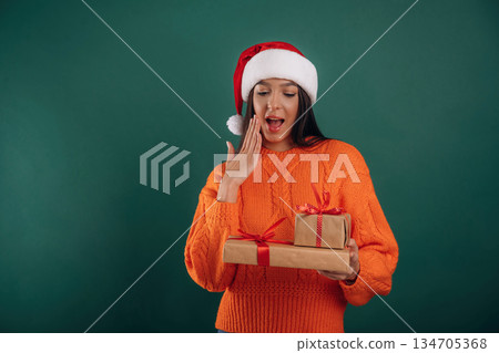 Wow, surprised, holding gift boxes. Young beautiful woman is against background Wow, surprised, holding gift boxes. Young beautiful woman is against background 134705368