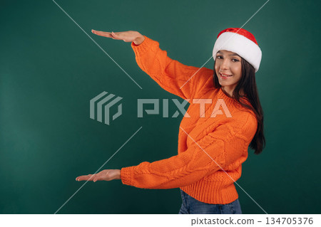 Invisible object in hands, copy space. Young beautiful woman is against background Invisible object in hands, copy space. Young beautiful woman is against background 134705376