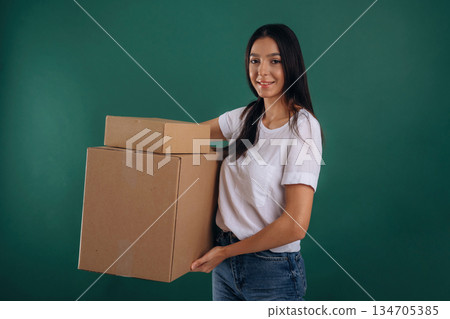Delivery service, holding box. Young beautiful woman is against background 134705385
