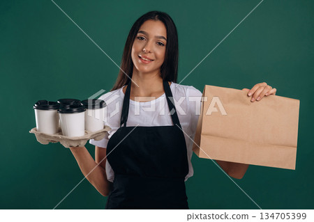Your order is ready, with coffee. Young beautiful barista is against background 134705399