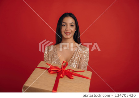 Celebration of new year, with gift. Young elegant woman is against background Celebration of new year, with gift. Young elegant woman is against background 134705420