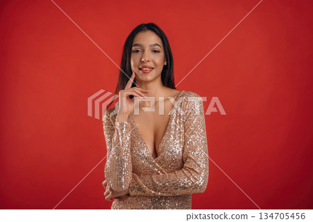 Looking forward, standing. Young elegant woman is against background 134705456