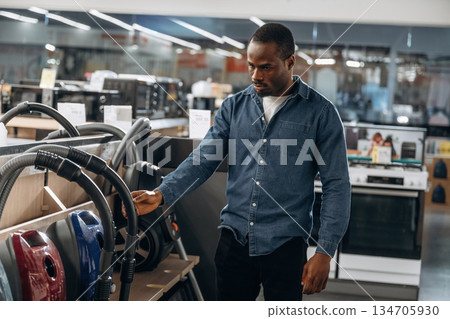 Vacuum cleaners. Man in a home appliance store Vacuum cleaners. Man in a home appliance store 134705930