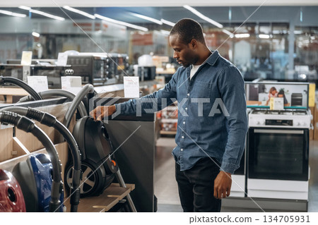 Vacuum cleaners. Man in a home appliance store Vacuum cleaners. Man in a home appliance store 134705931