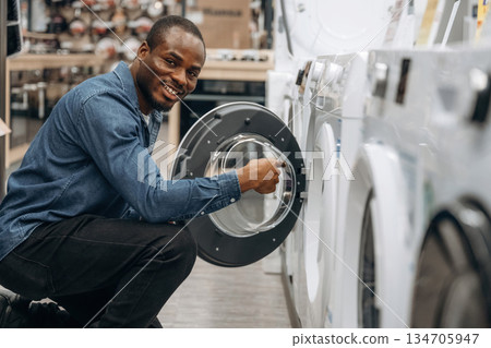 By washing machine. Man in a home appliance store 134705947