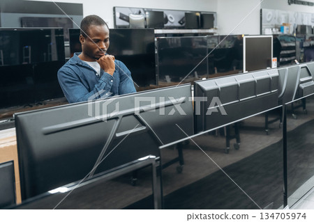 New TV. Big screen. Man in a home appliance store New TV. Big screen. Man in a home appliance store 134705974