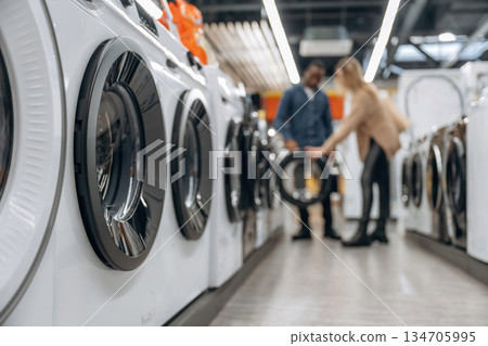 Man and woman are choosing washing machine in the store Man and woman are choosing washing machine in the store 134705995