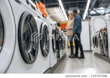 Man and woman are choosing washing machine in the store Man and woman are choosing washing machine in the store 134705996