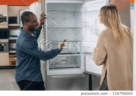 Man with woman are choosing fridge in the shop Man with woman are choosing fridge in the shop 134706004