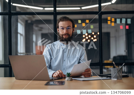 Friendly businessman is working in the office Friendly businessman is working in the office 134706099