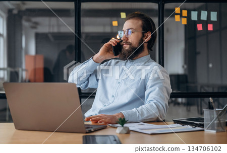 Talking by phone. Businessman is working in the office Talking by phone. Businessman is working in the office 134706102