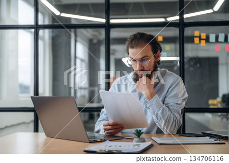 Reading the document. Businessman is working in the office Reading the document. Businessman is working in the office 134706116