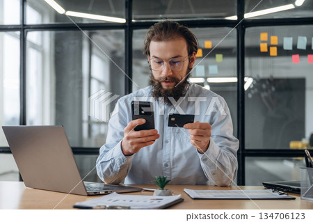 Transaction, using credit card and phone. Businessman is working in the office 134706123