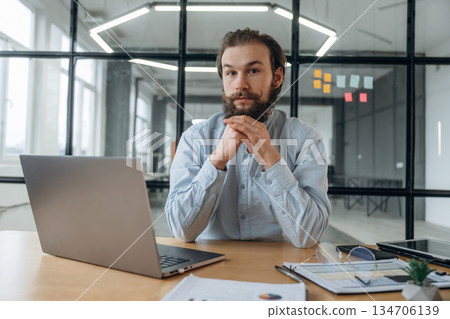Front view, by laptop. Businessman is working in the office 134706139