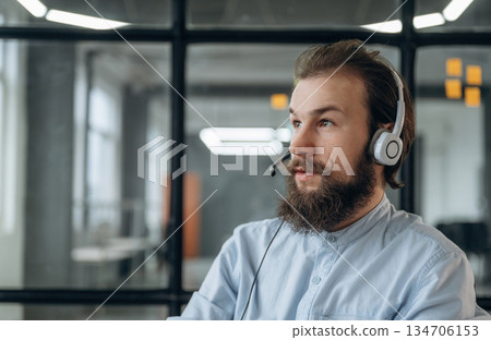 Call center or online conference, in headphones. Businessman is working in the office Call center or online conference, in headphones. Businessman is working in the office 134706153
