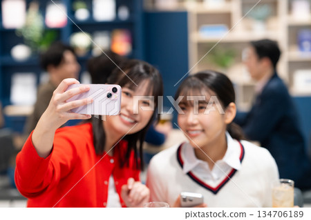 Young woman taking a photo at a drinking party 134706189