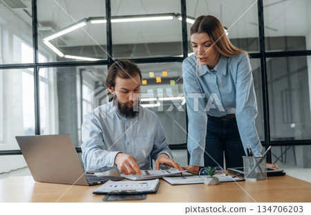 Talking, working with documents. Man and woman are in the office together Talking, working with documents. Man and woman are in the office together 134706203