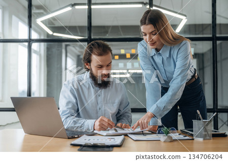 Talking, working with documents. Man and woman are in the office together Talking, working with documents. Man and woman are in the office together 134706204