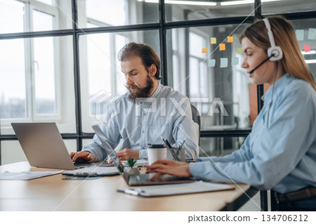 Working by laptops. Man and woman are in the office together 134706212