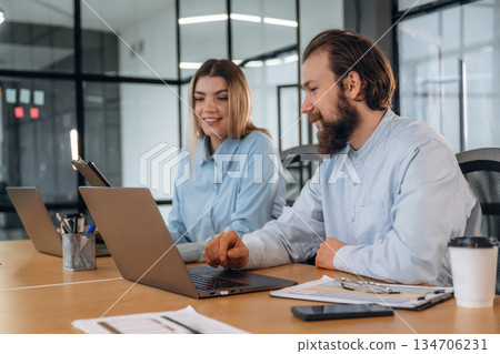 Successful, smiling and working. Man and woman are in the office together 134706231