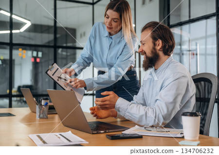 Successful, smiling and working. Man and woman are in the office together Successful, smiling and working. Man and woman are in the office together 134706232