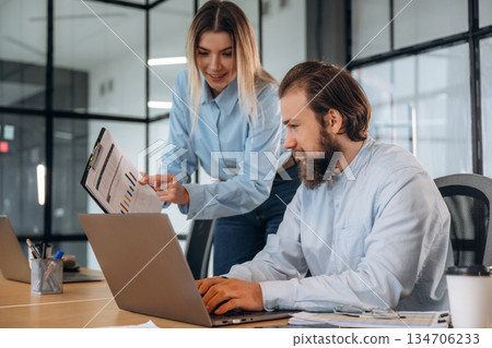 Successful, smiling and working. Man and woman are in the office together 134706233