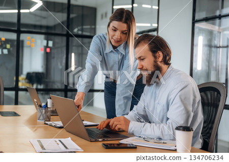 Successful, smiling and working. Man and woman are in the office together Successful, smiling and working. Man and woman are in the office together 134706234