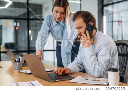 Man and woman are in the office together Man and woman are in the office together 134706235
