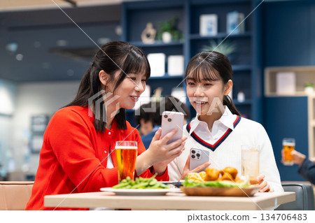 年輕女子在女孩聚會上看著智慧型手機 134706483