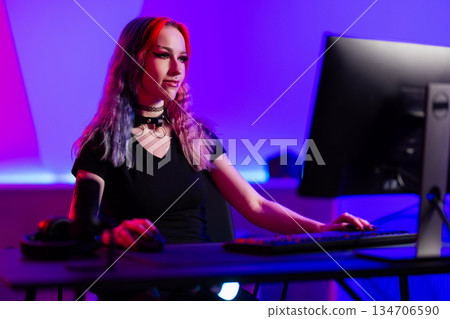 Young woman gaming on desktop computer in modern studio setup Young woman gaming on desktop computer in modern studio setup 134706590