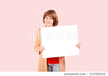 Happy woman holding blank poster mockup Happy woman holding blank poster mockup 134706593