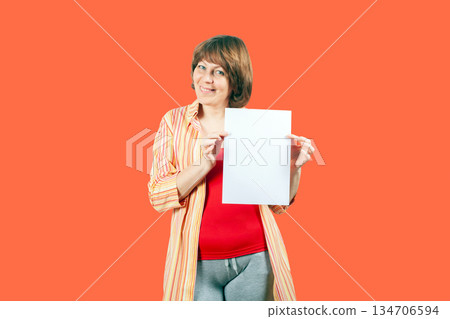 Smiling young woman holding poster mockup Smiling young woman holding poster mockup 134706594