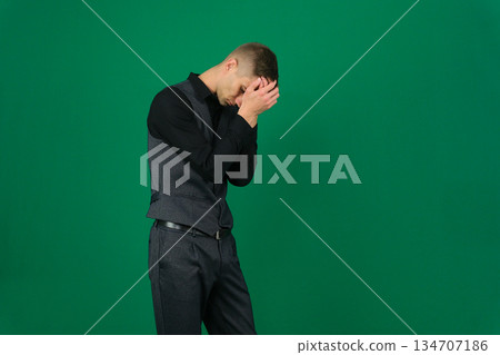 A man in business attire stands outdoors leaning against a wall, appearing stressed. The image conveys themes of pressure, work tension, and contemplation A man in business attire stands outdoors leaning against a wall, appearing stressed. The image conveys themes of pressure, work tension, and contemplation 134707186