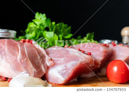 Raw Meat with Tomatoes Garlic and Parsley on Cutting Board 134707933