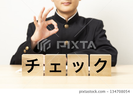 一名男學生用寫著「check」的積木比出OK手勢 一名男學生用寫著「check」的積木比出OK手勢 134708054