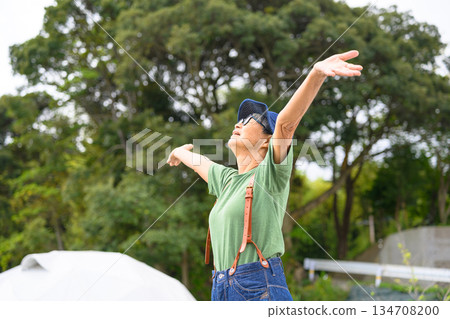 Senior woman with arms outstretched outdoors [Photo courtesy of Oki Seaside Resort Miyabi] 134708200