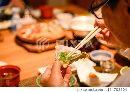 Seniors eat oysters with chopsticks 134708204