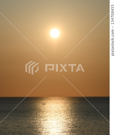 一艘船漂浮在海面上，陽光普照。 134708455
