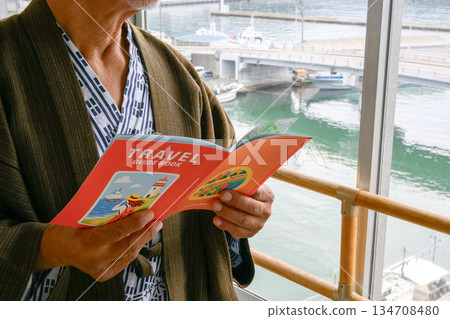 Man reading a guidebook 134708480