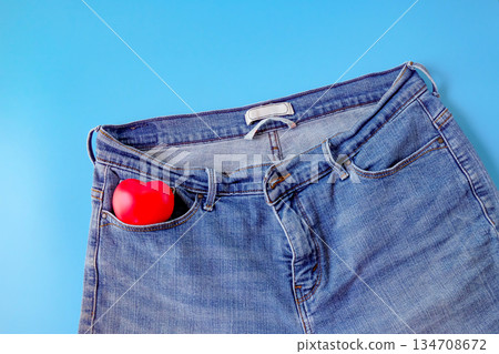 Red heart in blue jeans pocket, concept of romance. 134708672